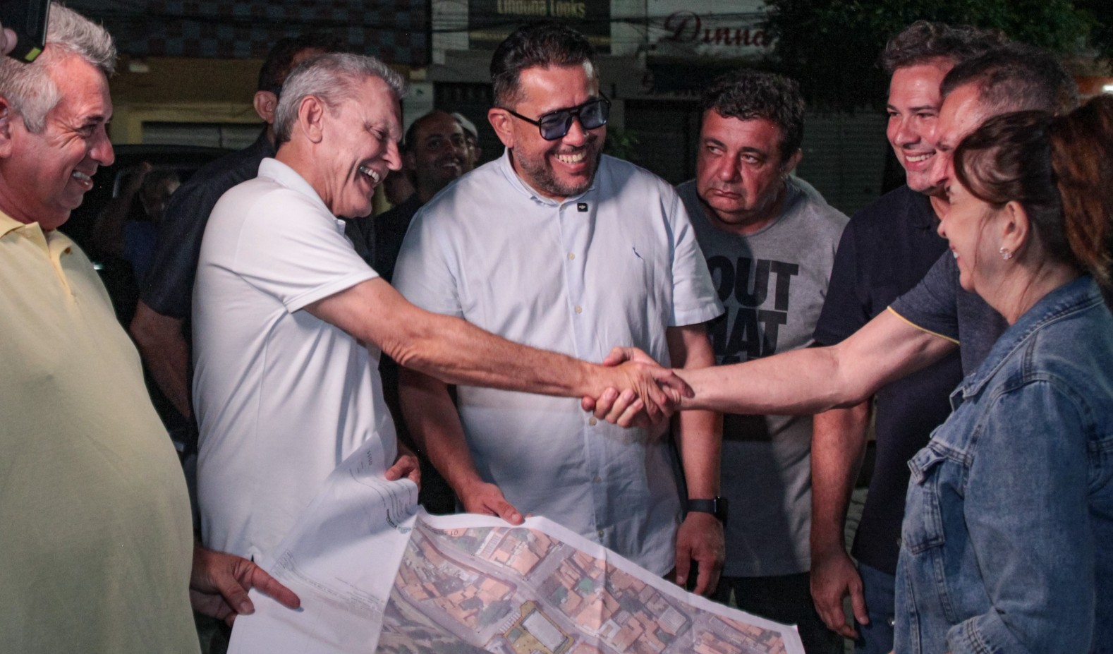 prefeito aperta a mão de um homem enquanto olha planta da obra